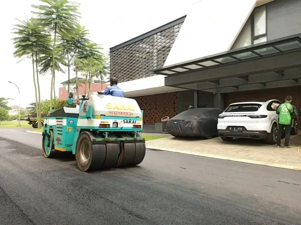Tim profesional Kerajaan Aspal sedang menghampar hotmix AC-WC di area parkir pabrik Jakarta